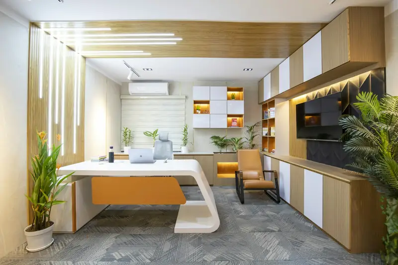 Bright executive office with a white curved desk, timber wall panelling, built-in storage and indoor plants